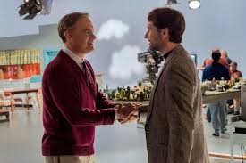 Tom Hanks, as Fred Rogers, shakes hands with journalist Lloyd Vogel, played by Matthew Rhys. 